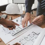 A construction team goes over a pre-construction checklist for a commercial remodeling project at a desk